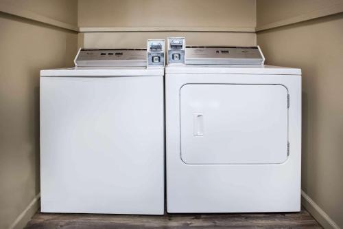 two white refrigerators sitting next to each other in a room at Travel Inn Of Sidney Ohio in Sidney