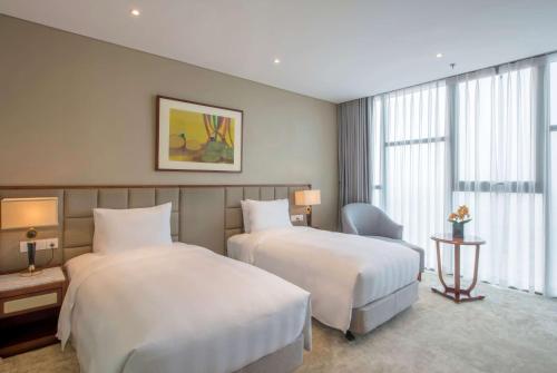 a hotel room with two beds and a window at Wyndham Garden Hanoi in Hanoi