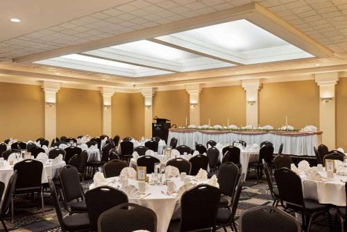a banquet hall with tables and chairs with white table settings at Royal Hotel Regina, Trademark Collection by Wyndham in Regina