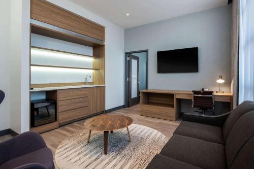 a living room with a couch and a desk at Wingate by Wyndham Long Island City in Queens