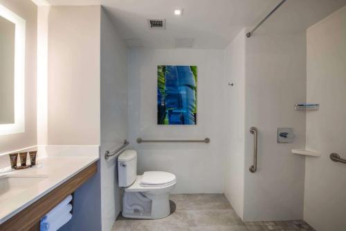 a white bathroom with a toilet and a sink at Wingate by Wyndham Long Island City in Queens