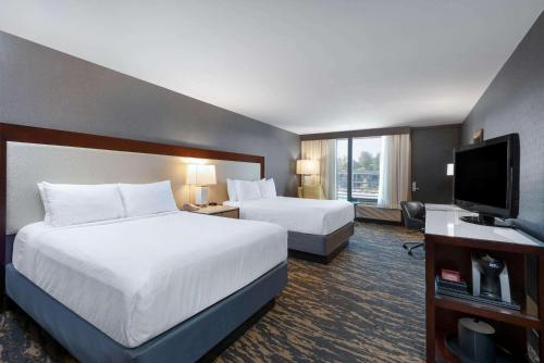 a hotel room with two beds and a flat screen tv at Wyndham Lancaster Resort and Convention Center in Lancaster