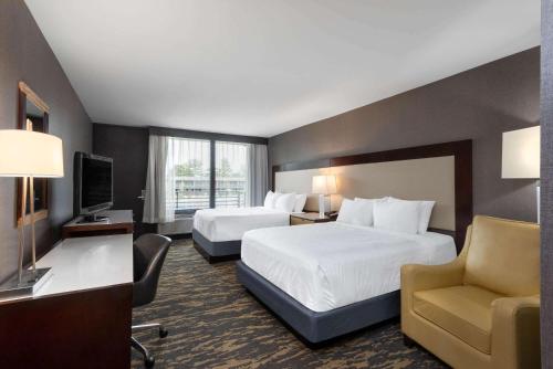 a hotel room with two beds and a television at Wyndham Lancaster Resort and Convention Center in Lancaster