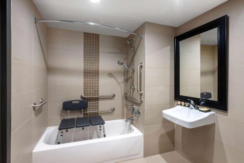 a bathroom with a tub and a sink and a mirror at Wyndham Lancaster Resort and Convention Center in Lancaster