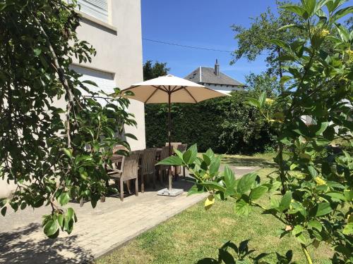 a patio with a table and an umbrella at AFamily HomeDating Backto the endof the19thCentury in Les Bulles