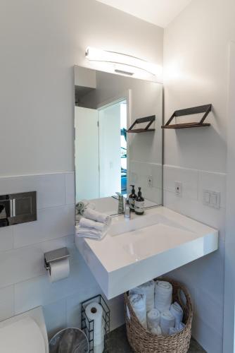 a white bathroom with a sink and a mirror at Anchor Inn Pacifica in Pacifica