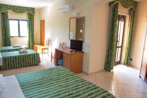 a hotel room with two beds and a television at Hotel San Giorgio in San Nicola Arcella