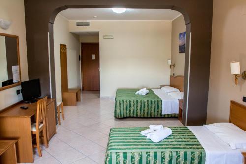 a hotel room with two beds and a television at Hotel San Giorgio in San Nicola Arcella