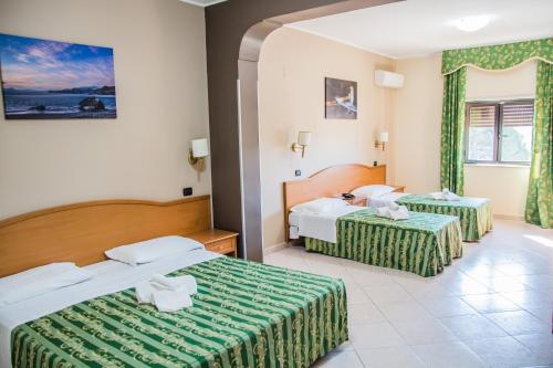 a hotel room with two beds and a bathroom at Hotel San Giorgio in San Nicola Arcella