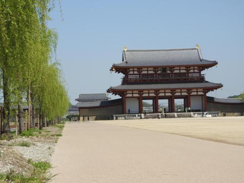 an asian building with a sidewalk in front of it at Business Hotel Century in Nara