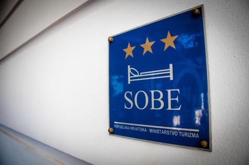 a blue sign on a wall with stars on it at Tamaris Rooms in Zadar