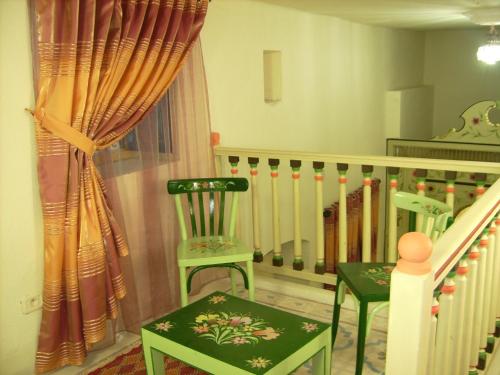 a room with two green chairs and a staircase at Dar Baaziz in Sousse