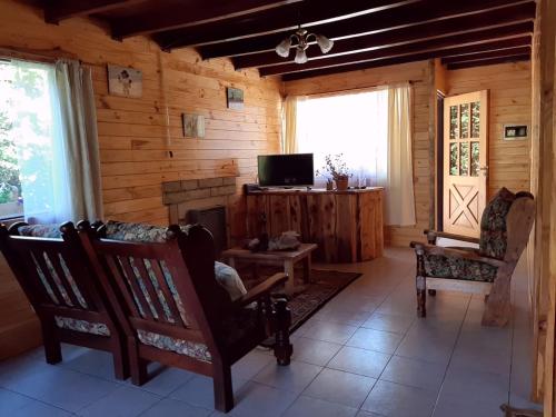a living room with rocking chairs and a fireplace at Las Rosas Alojamiento Turistico in Villa La Angostura