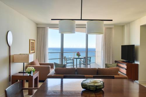 a living room with a couch and a table at Ka Laʻi Waikiki Beach, LXR Hotels & Resorts in Honolulu