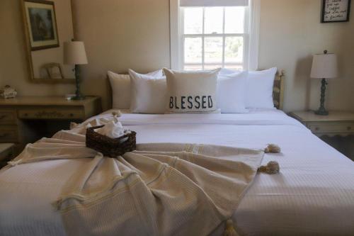 a large white bed with a dress on it at La Villa de Adelina in Ensenada