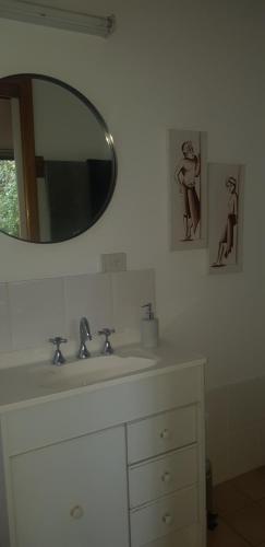 y baño con lavabo blanco y espejo. en Samurai Beach Bungalows - Port Stephens YHA, en Anna Bay