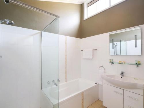 a bathroom with a glass shower and a sink at Family Beachside Getaway with BBQ and Patio in Terrigal