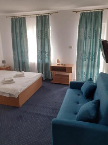 a room with a blue couch and a bed at Casa Azugeana in Azuga