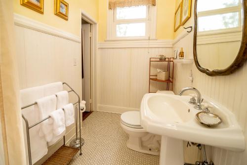 a bathroom with a sink and a toilet and a mirror at The Blenman Inn in Tucson
