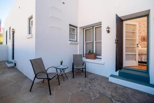 a patio with two chairs and a table and a door at The Blenman Inn in Tucson