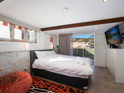 a bedroom with a large bed and a large window at Cosy Studio With Deck, Close to Shops and Beach in Terrigal