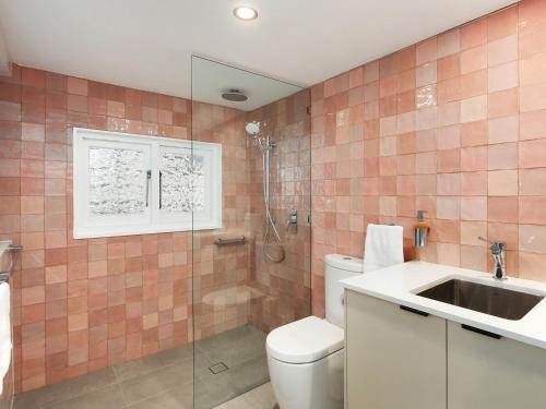 a bathroom with a toilet and a sink and a shower at Cosy Studio With Deck, Close to Shops and Beach in Terrigal