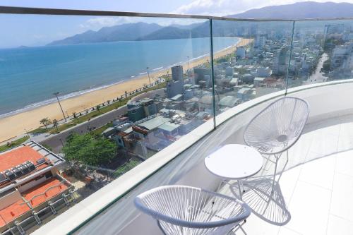 a balcony with two chairs and a view of the beach at TMS-PULLMAN MINH MINH Apartment in Quy Nhon