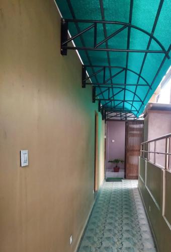 a hallway with a green ceiling and a tile floor at Woodland Lodge and Restaurant in Guwahati