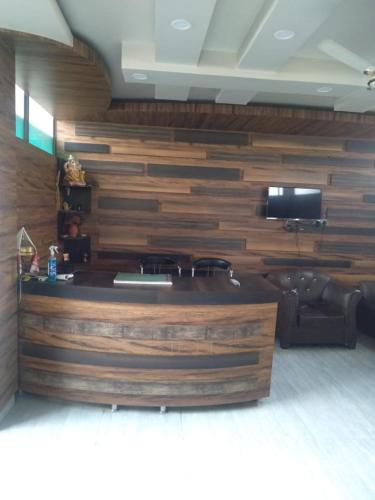 a living room with a large wooden wall at Woodland Lodge and Restaurant in Guwahati