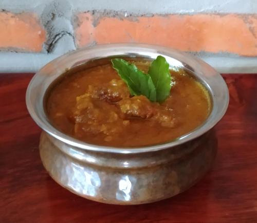 a bowl of soup with ailantro leaf on top at Pilgrim's Kitchen & Inn in Savannakhet