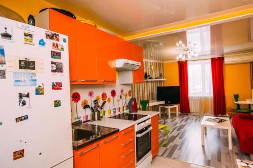 cocina con armarios naranjas y nevera blanca en Kakadu Hostel, en Khabarovsk