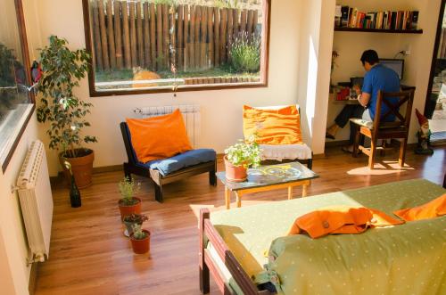 a man in a living room with orange pillows at Hostería Los Gnomos in El Calafate