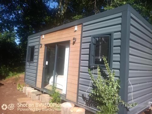 a grey shed with a door and windows at Isikhoma-Khoma in Hilton