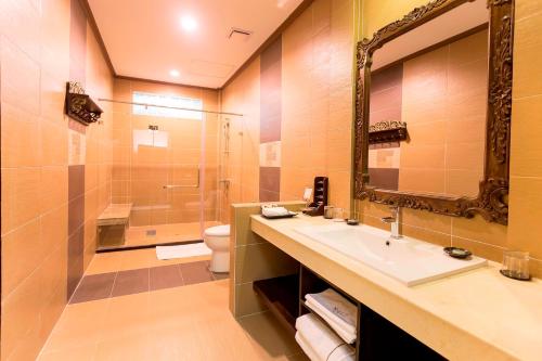 a bathroom with a sink and a toilet and a mirror at Bali Hotel in Phnom Penh