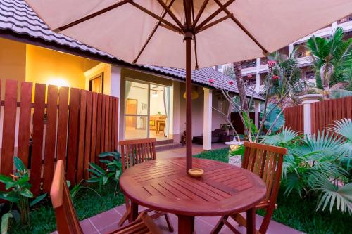 a wooden table with an umbrella on a patio at Bali Hotel in Phnom Penh
