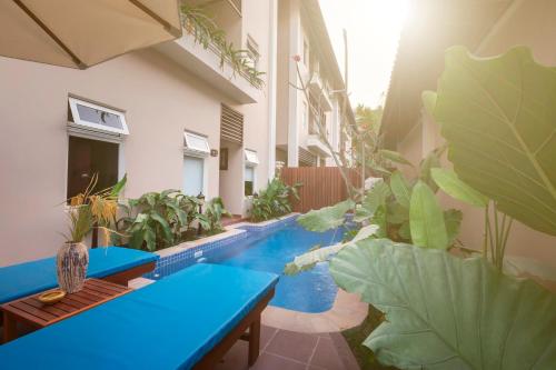 a patio with a blue bench and plants at Bali Hotel in Phnom Penh