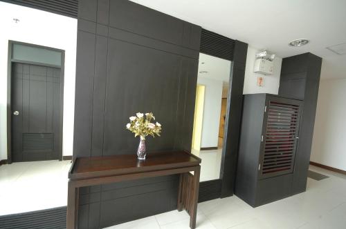 a vase of flowers on a table in a hallway at Rangsit Apartment II in Ban Talat Rangsit