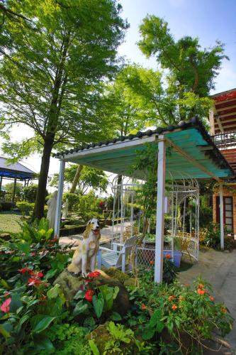 a dog sitting under a gazebo in a garden at Xin Yuan My Dream Castle in Dongshan