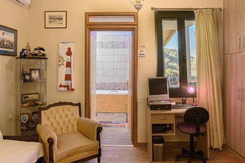 a bedroom with a desk with a computer and a chair at Villa Roxani in Mesklá