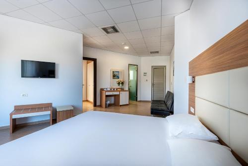 a bedroom with a bed and a living room at Royal Bay Suites in Kefalos