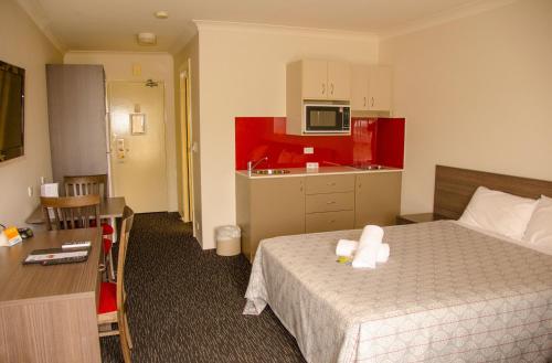 a hotel room with a bed and a kitchen at Hunts Hotel Liverpool in Liverpool