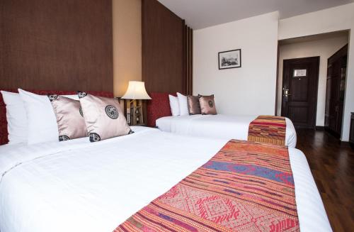 a hotel room with two beds with white sheets at Salana Boutique Hotel in Vientiane