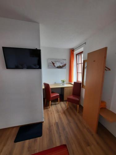 a living room with a table and a desk with chairs at Gasthaus & Pension Zum Göschen in Grimma