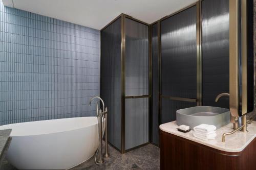 a bathroom with a tub and a sink at Mondrian Seoul Itaewon in Seoul