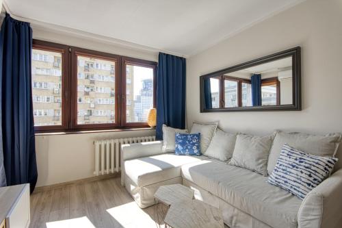 ein Wohnzimmer mit einem Sofa und einem Spiegel in der Unterkunft Pańska Residence in Warschau