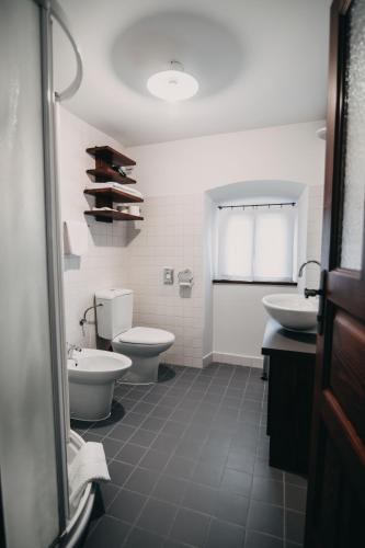 a bathroom with two toilets and a sink and a toilet istg at Hotel Dvor Jezersek Brnik in Cerklje na Gorenjskem