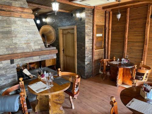 a restaurant with tables and chairs and a fireplace at Vila Prezident in Sremski Karlovci