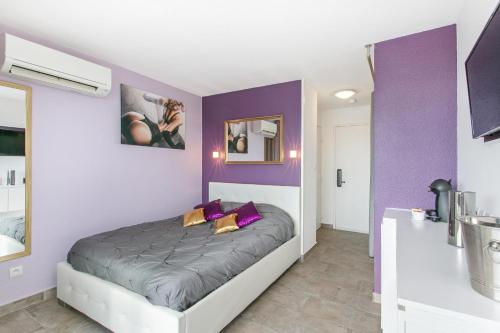 um quarto com uma cama com paredes roxas em Village Naturiste R4N - Le Candi Port Venus Panoramic View em Cap d'Agde