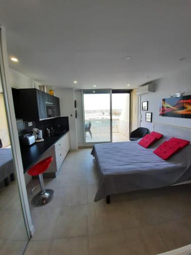 une chambre avec un lit et une vue sur la plage dans l'établissement Naturiste Cap d'Agde Héliopolis D 11, au Cap d'Agde