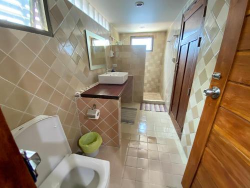a bathroom with a toilet and a sink at Tha Ma-O Bouteak homestay - ท่ามะโอบูทีคโฮมสเตย์ - pet friendly in Lampang